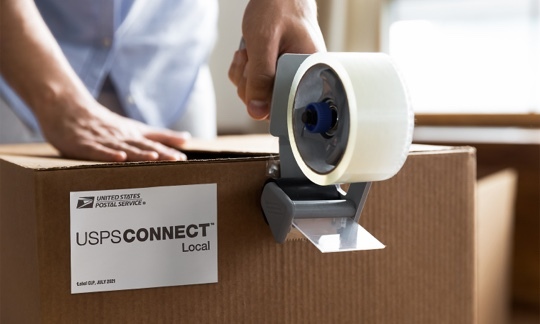 Package being prepared to ship with a sticker on it. saying 'goldrushdispatch Connect Local. Thank you for supporting local businesses.'