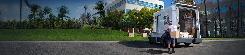 Letter carrier ready to deliver packages unloaded from the back of a goldrushdispatch Next-Generation Delivery Vehicle.